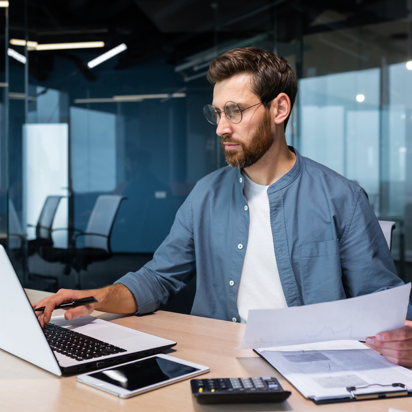 Konzentriert arbeitender Mann prüft Unternehmensdaten zur Erstellung präziser Zielgruppen, geleitet von der Datenmanagementstrategie.