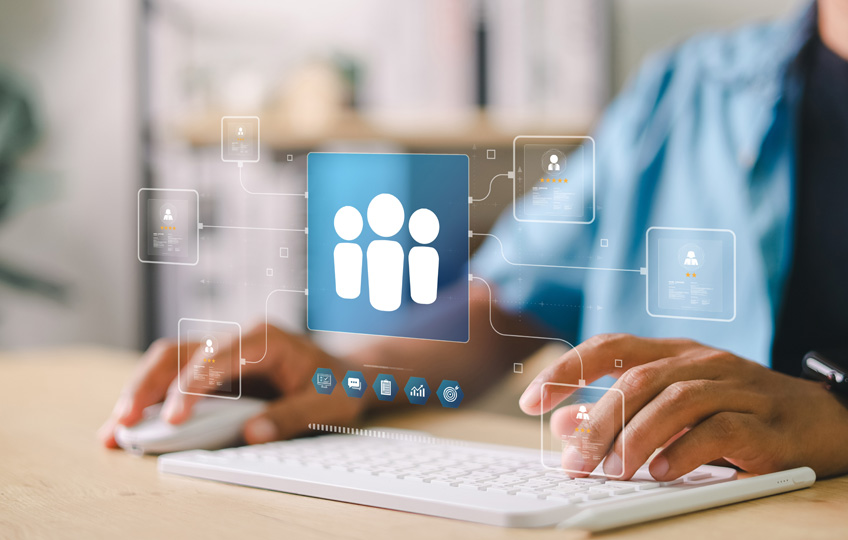 Das Bild visualisiert, wie eine Person am PC sitzt und an der Adressdatenbank seines Unternehmens arbeitet.