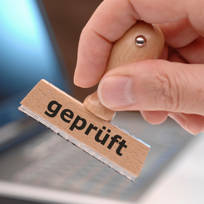 Der Stempel „Geprüft“ auf einem Dokument symbolisiert eine verlässliche Firmendatenbank als Basis für Kampagnen.